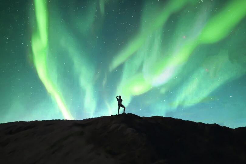 Image of a solitary person under aurora borealis being a loner