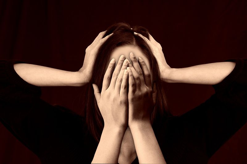 Image of a stressed woman holding her head in anxiety