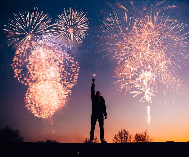 Image of an intense person standing under fireworks