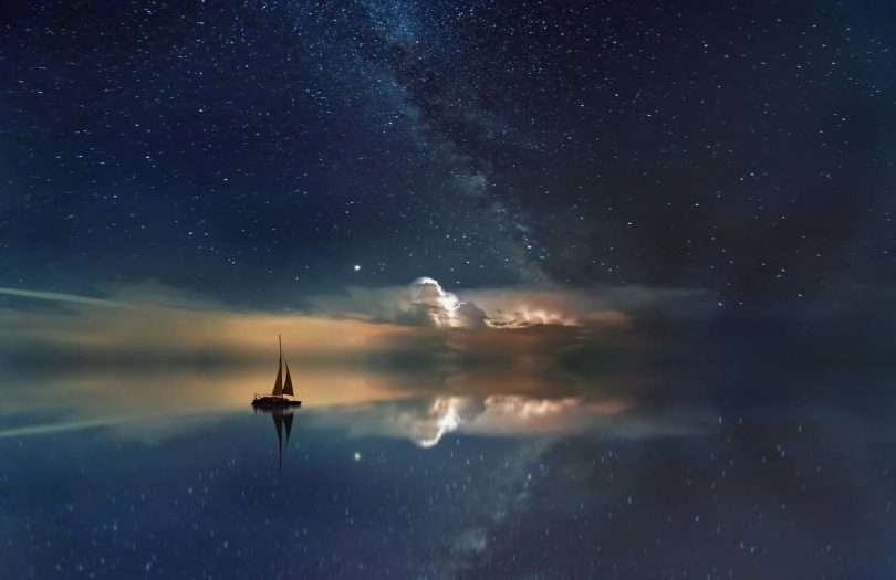 Image of a boat on the water under the stars