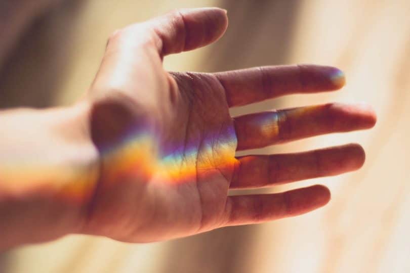 Image of a hand and rainbow symbolizing the many different spiritual paths