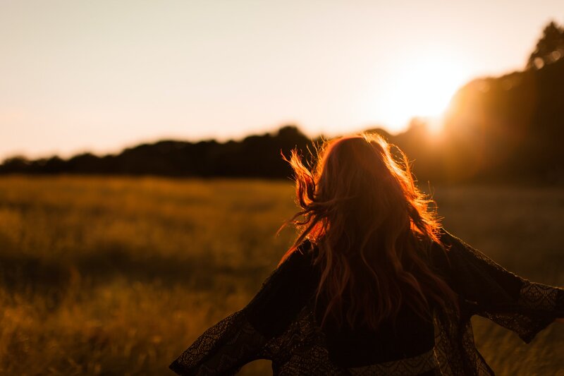 Image of a free and happy woman in a field of grass