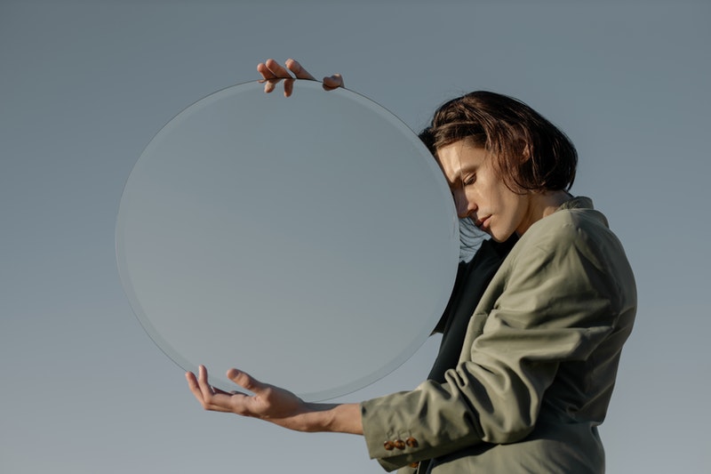 Image of a man holding up a mirror symbolic of having a sense of entitlement