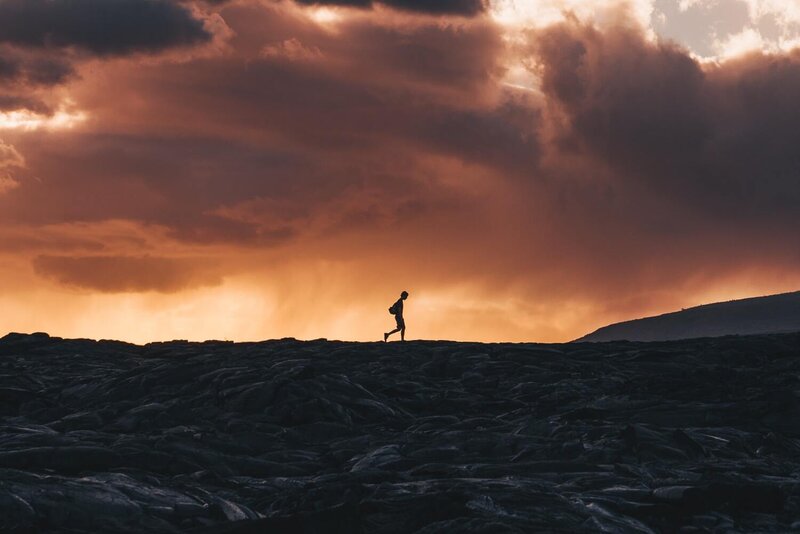 Image of a solitary person walking on a volcanic landscape