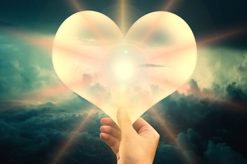 Image of a person holding a light-filled heart