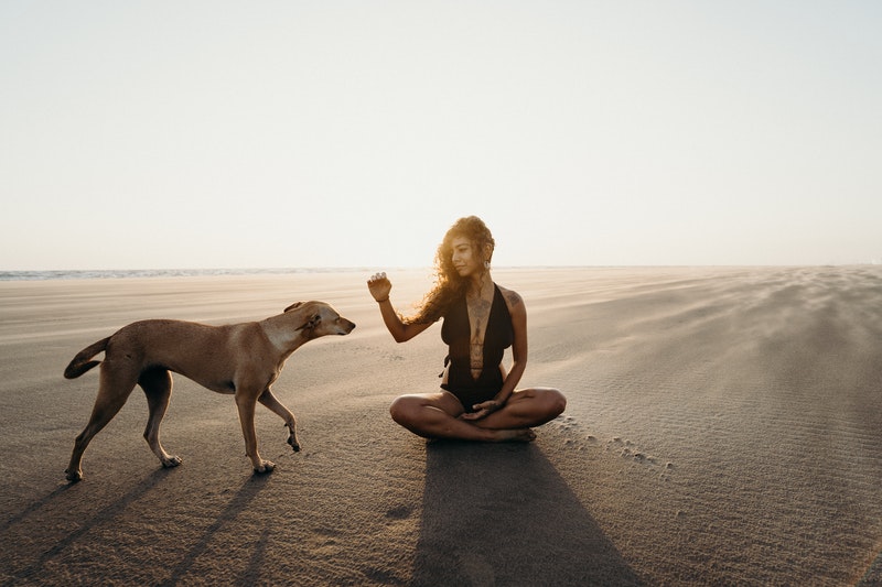 Image of a woman in the desert and her dog