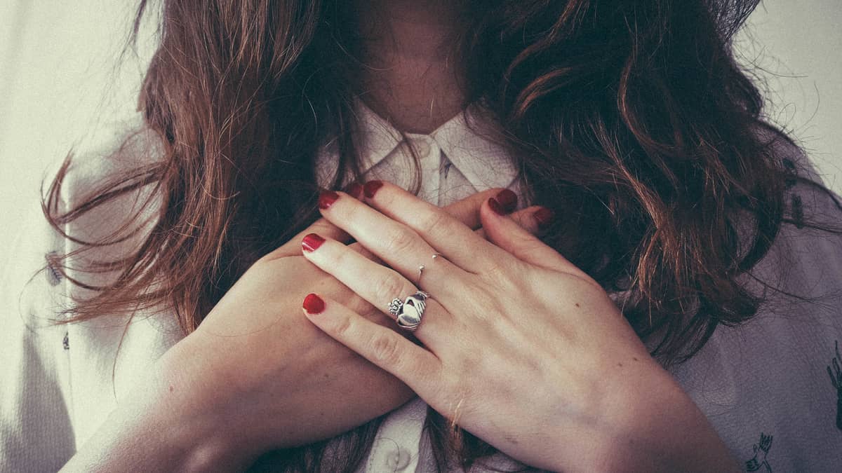 Image of a woman with hands over her heart feeling self-love