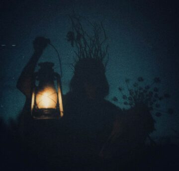 Image of a spooky woman holding a lantern and a skull symbolic of the shadow self