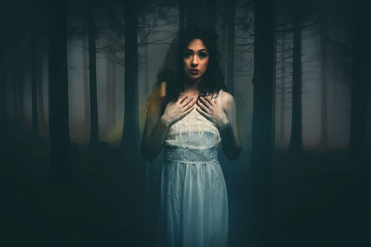 Image of a ghostly woman in a dark forest experiencing soul loss