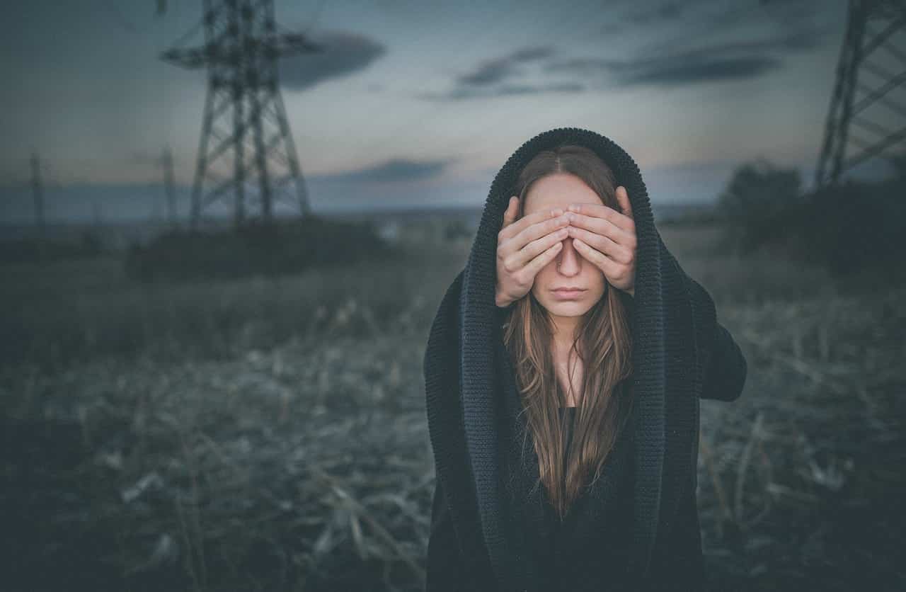 Image of a woman covering eyes having unwanted thoughts