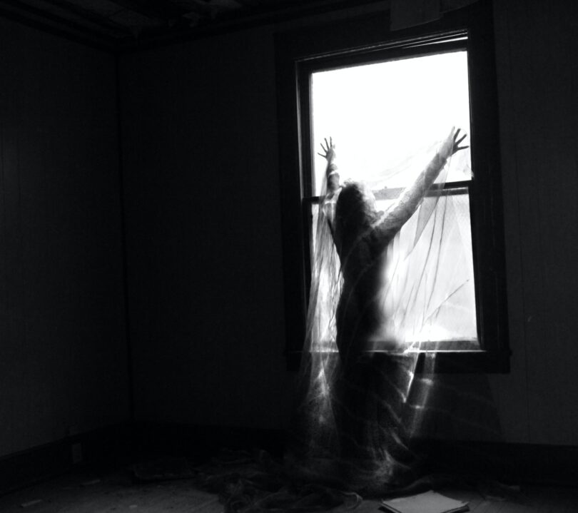 Image of a ghostly woman reaching up to the window symbolic of the shadow self