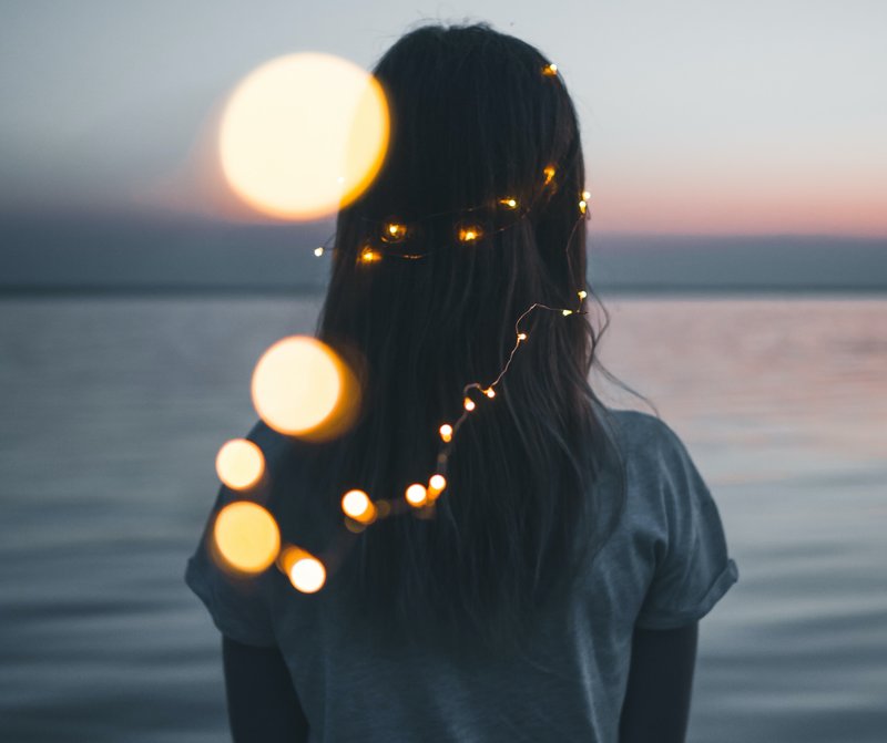 Image of a woman standing in front of the ocean on her spiritual psychology path