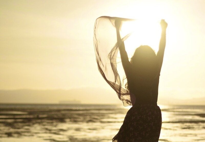 Image of a happy woman in the sunshine free from toxic core beliefs