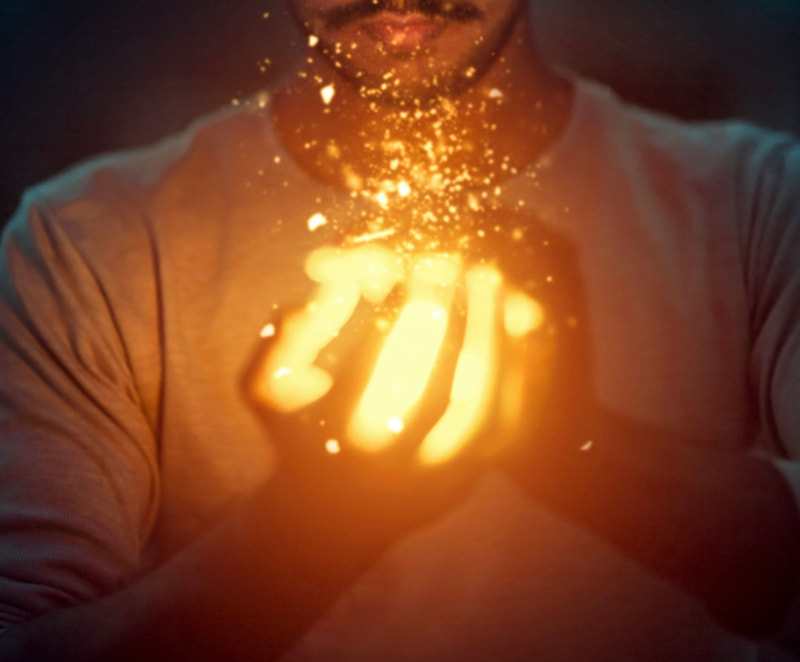 Image of a man holding a ball of golden light symbolic of the Philospher's Stone