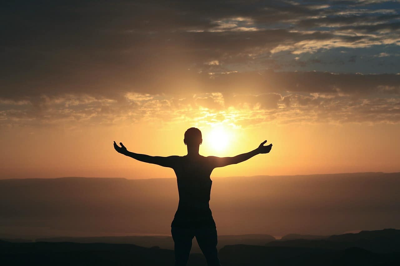 Image of a happy man staring at the sun symbolic of learning how to love yourself