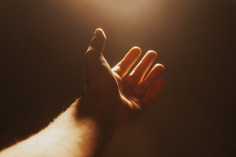 Image of a person reaching out to the light