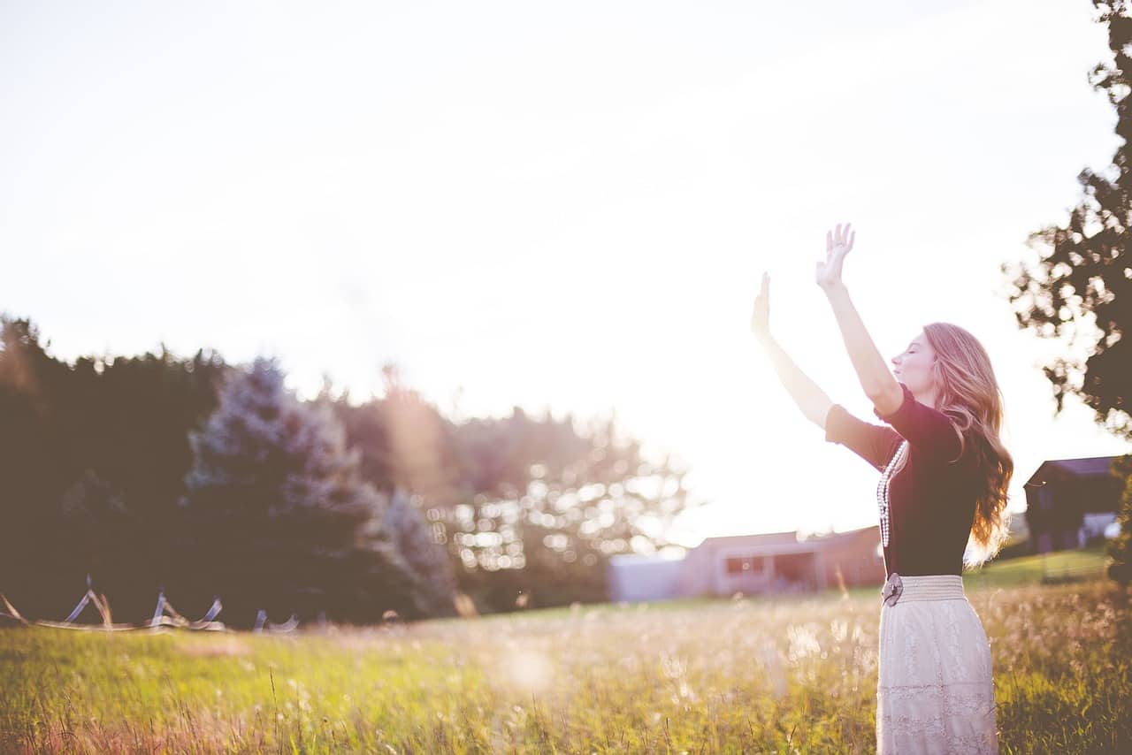 Image of a happy woman in the sunlight who feels whole