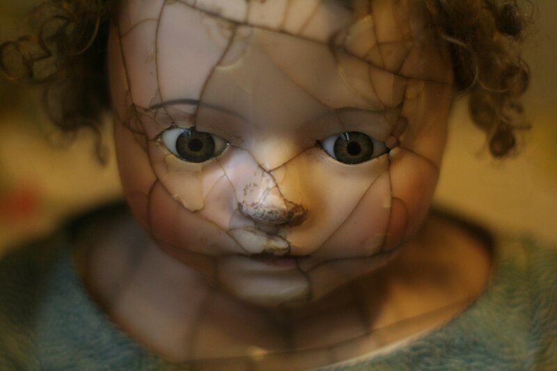 Image of a creepy doll face that represents childhood trauma