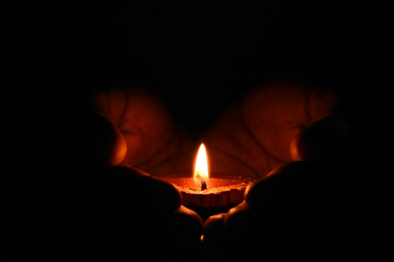 Image of a person holding a candle symbolic of soul work