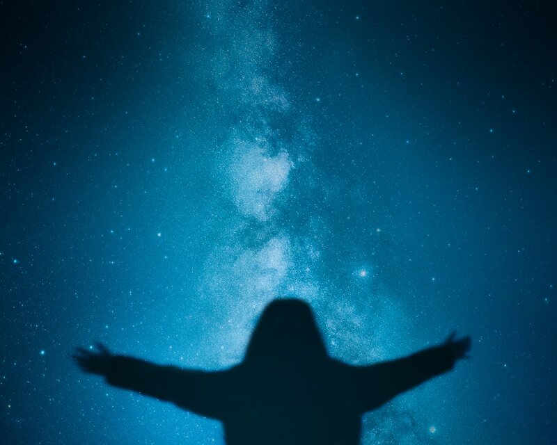 Image of an empath woman opening her arms to the cosmos