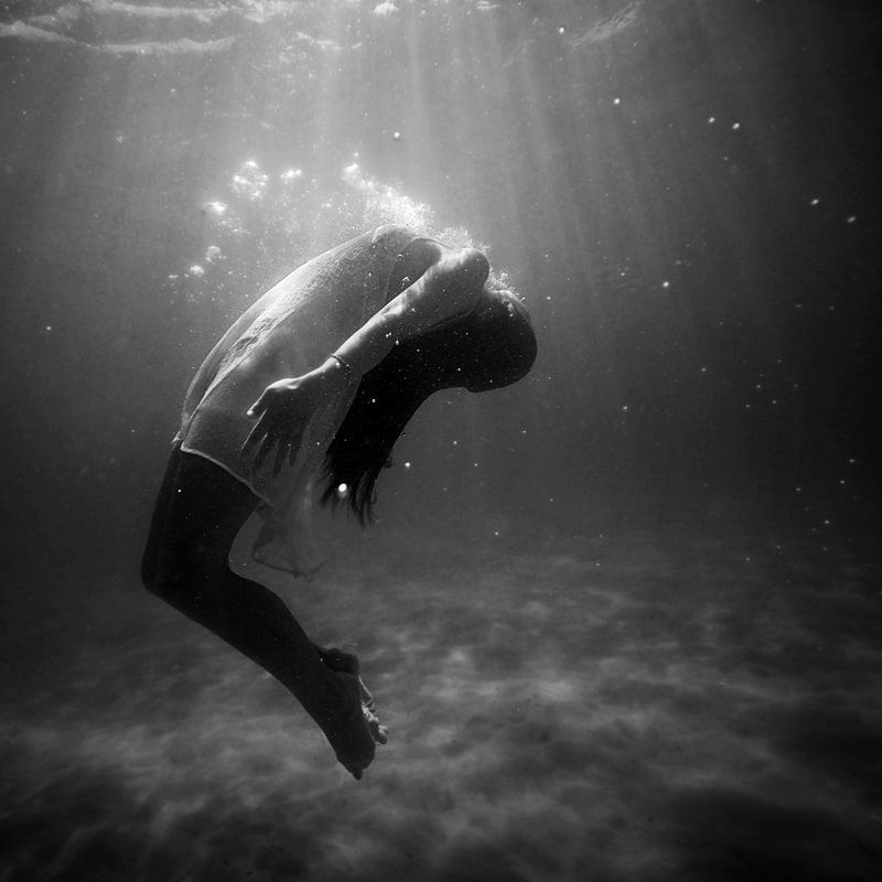 Image of a woman drowning in water symbolic of the dark night of the soul