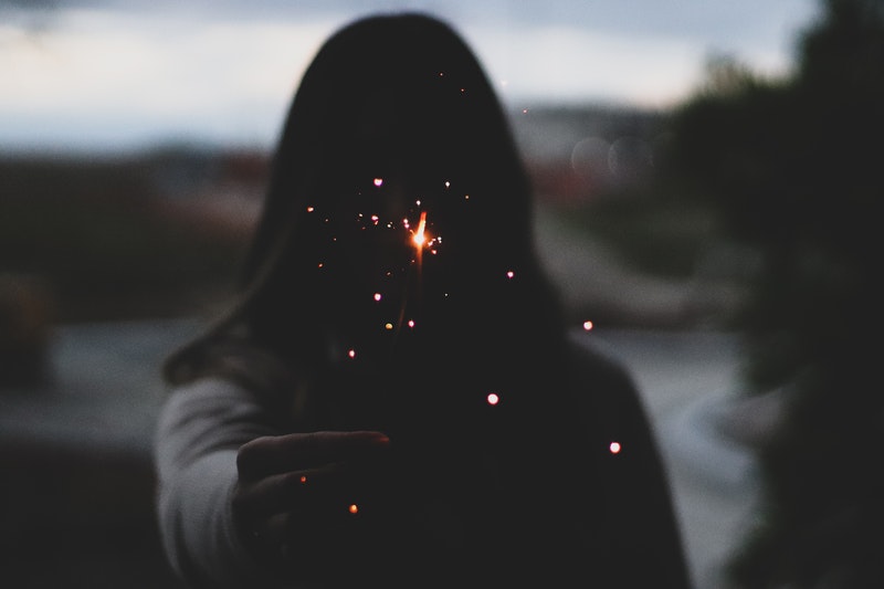 Image of a woman holding up a sparkler