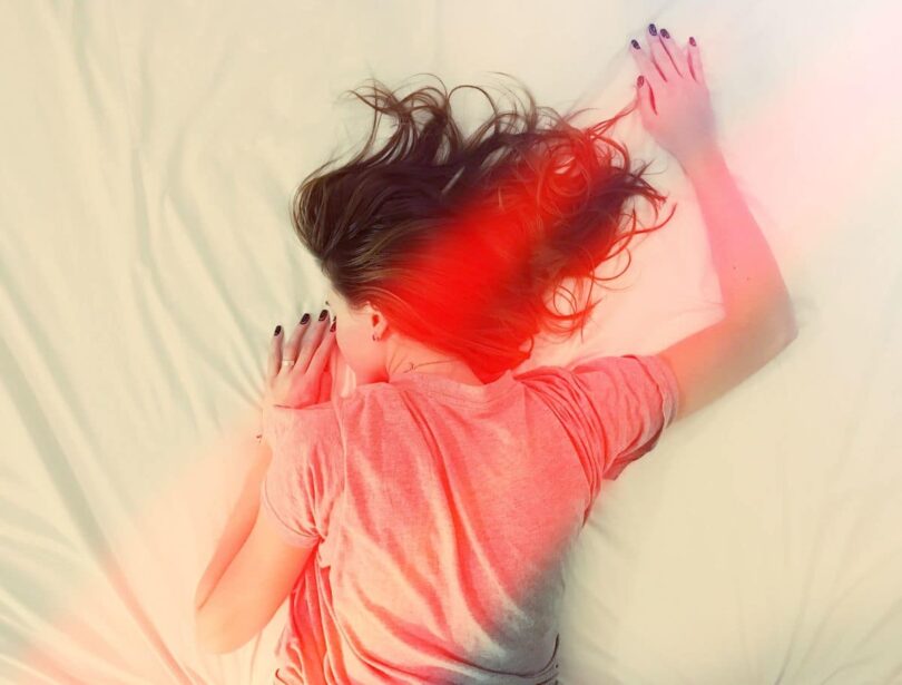 Image of a woman lying in bed with muscle tension