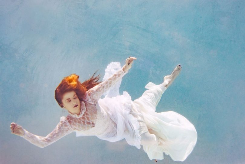 Image of a woman floating in the water symbolic of non-attachment