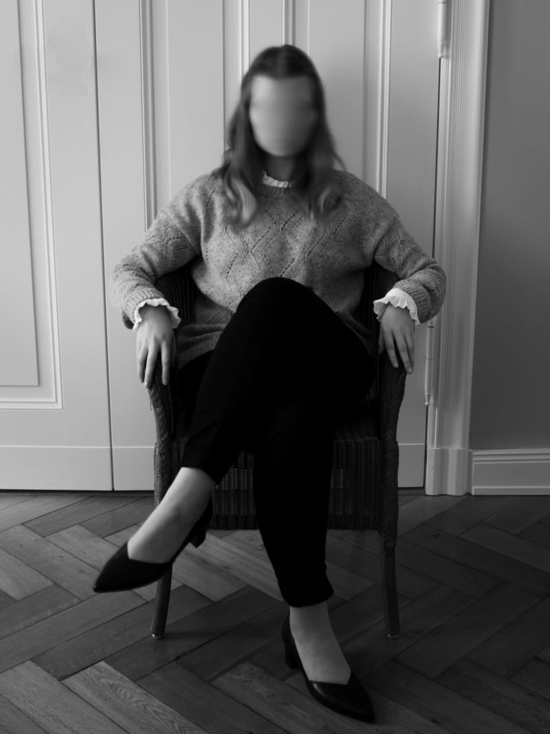 Image of a woman sitting with no face