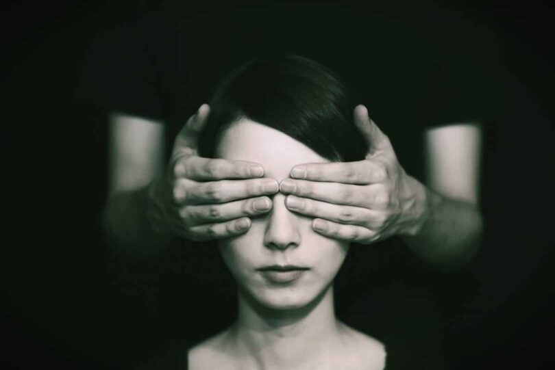 Image of a woman with hands covering her eyes blocking her spiritual discernment