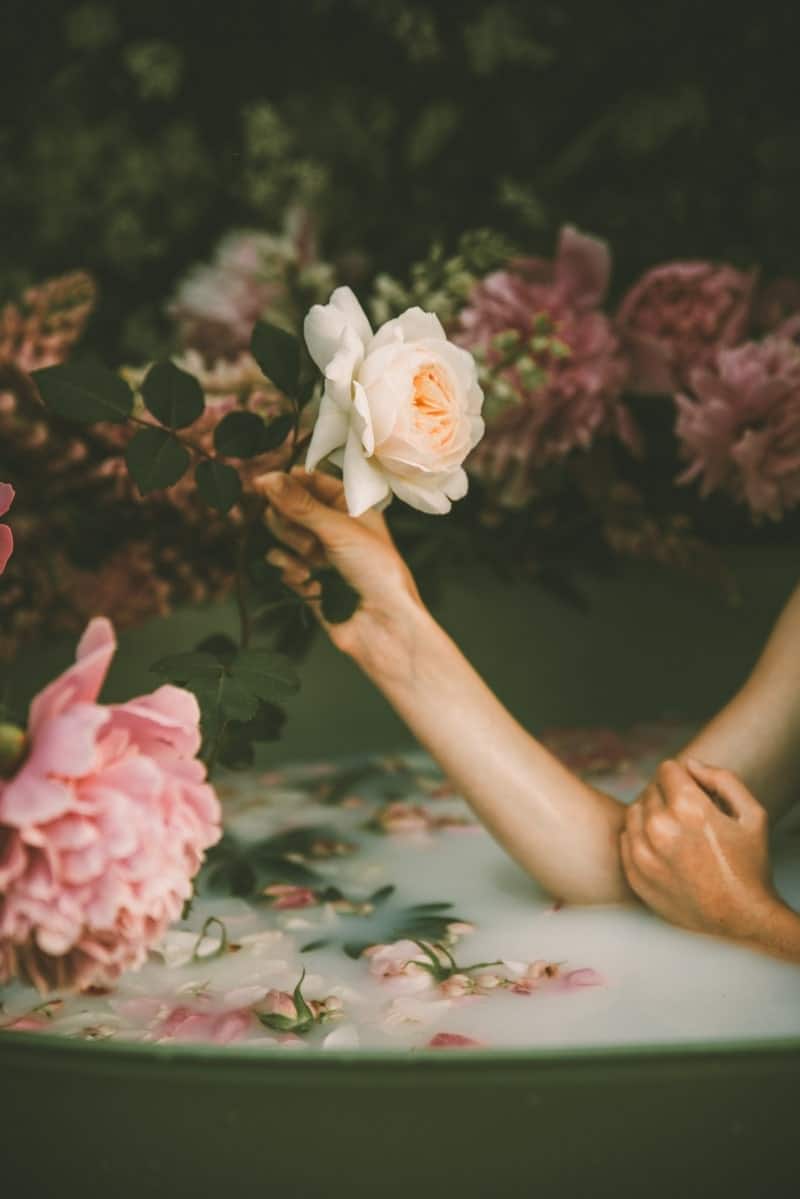 Image of a sensual woman in a bathtub surrounded by roses