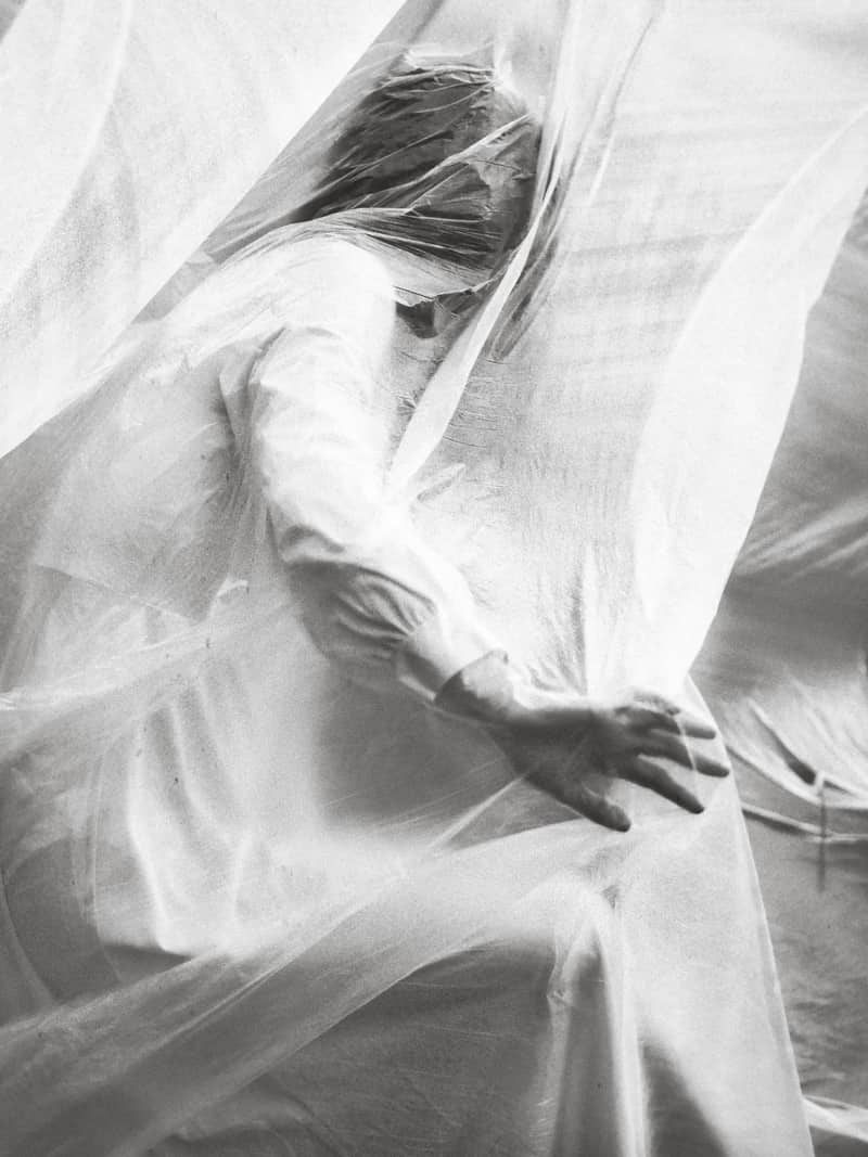 Image of a woman avoiding conflict in a white curtain symbolic of toxic positivity