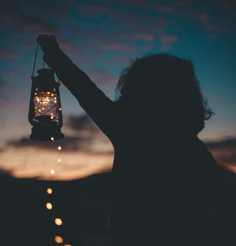 Image of a man holding a lantern in the dark
