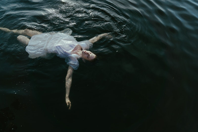 Image of a depressed woman floating on a dark sea