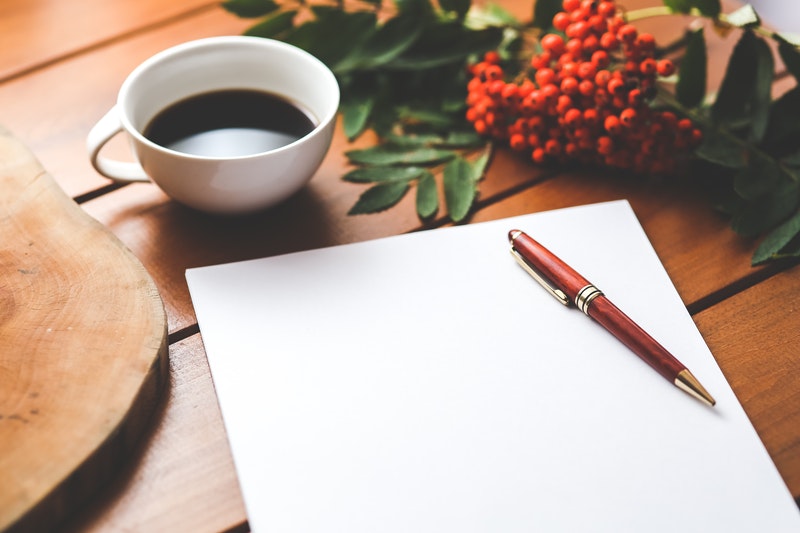 Image of a piece of paper, pen and cup of tea