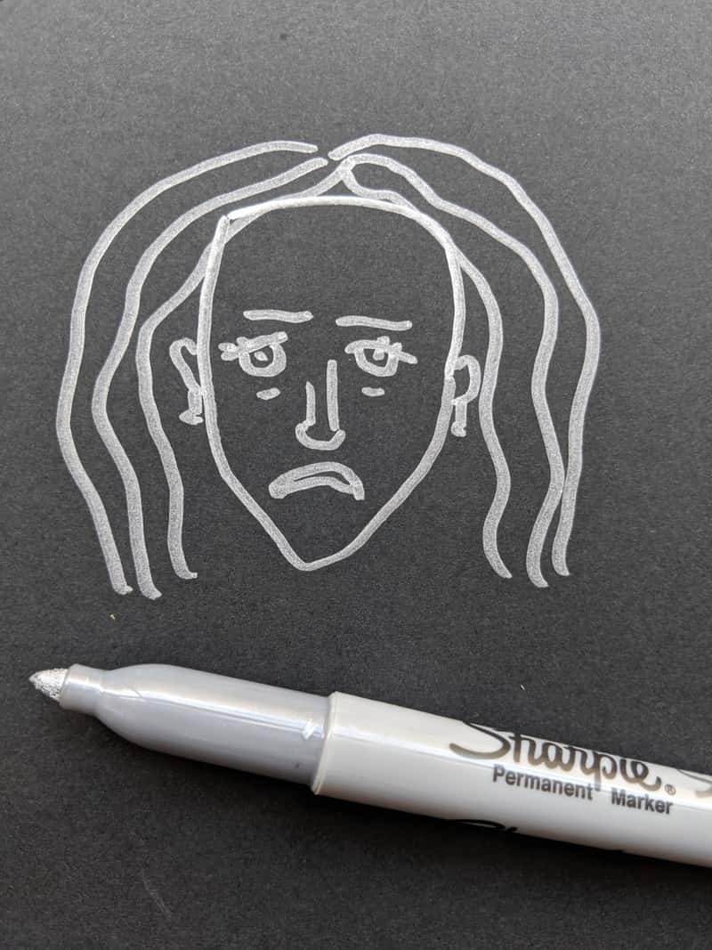 Image of a sad face drawn on paper as an art therapy idea