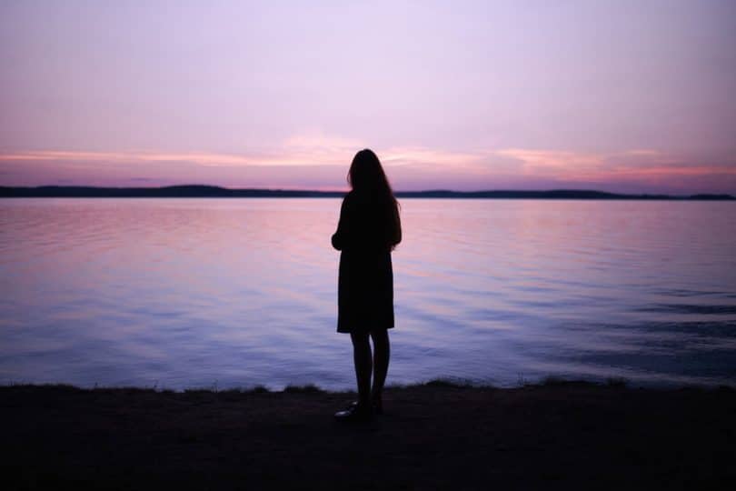 Image of a woman in front of a lake soul searching