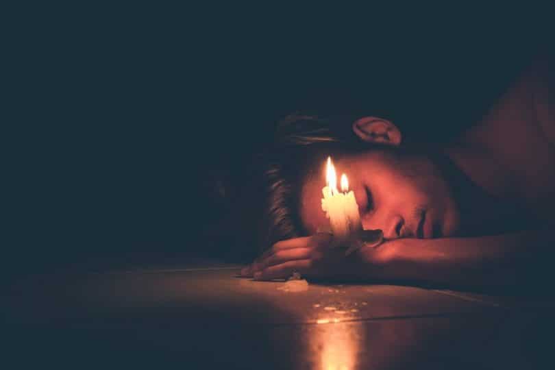 Image of a depressed man and a candle symbolic of the spiritual emergency