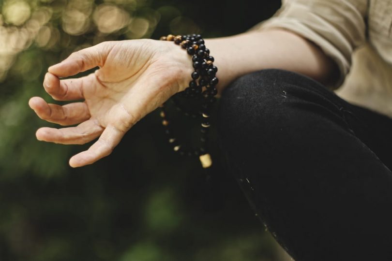 Image of a meditation person doing a mudra representing spiritual materialism