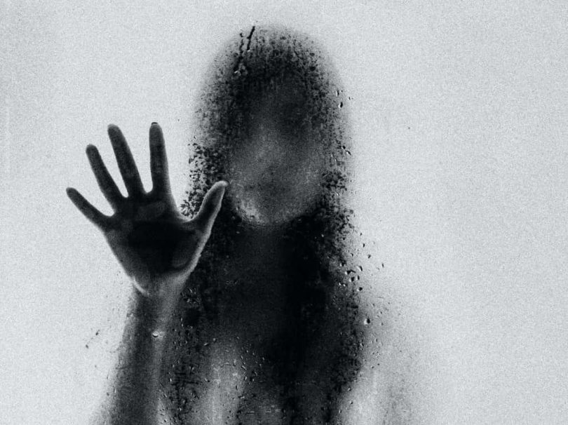 Image of a ghostly woman behind a window pane