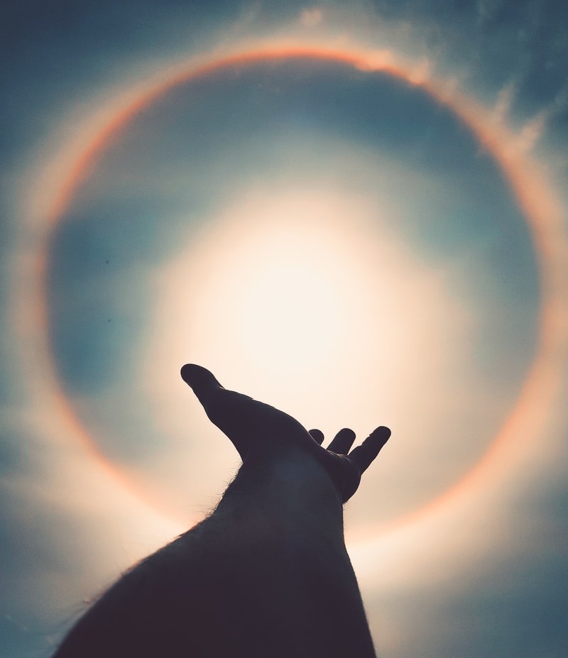 Image of a man reaching up to the sun