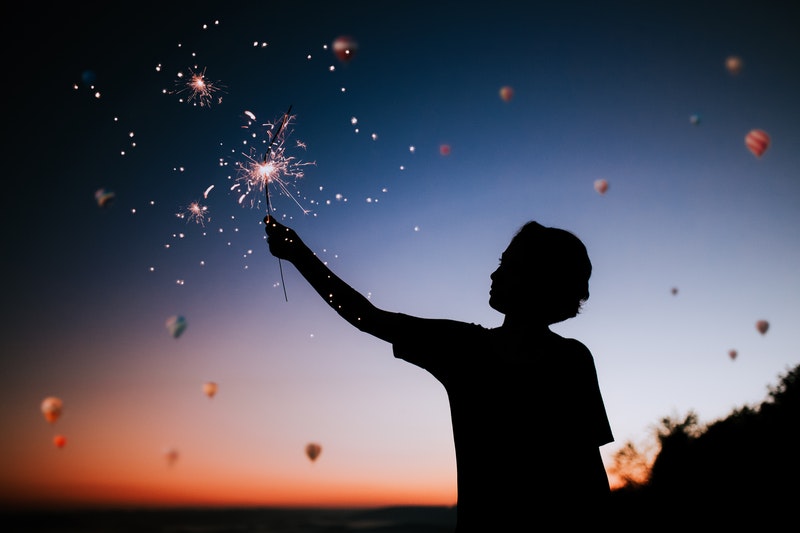 Image of a boy at sunset with a sparkler