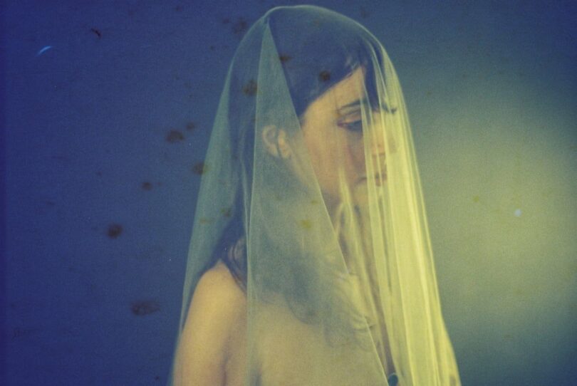 Image of a sad woman struggling with self-forgiveness with a veil over her head