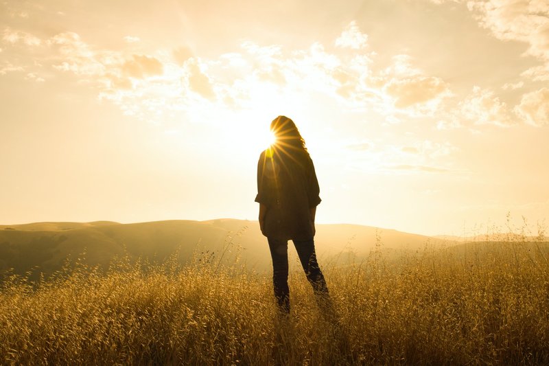 Image of a woman standing in a yellow field of grass