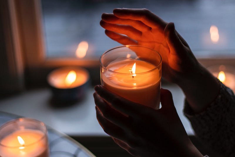 Image of a person holding a candle symbolic of spiritual healing