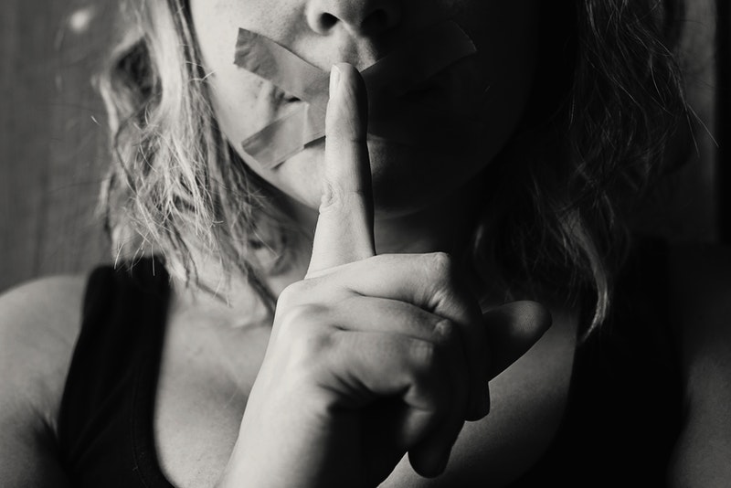 Image of a woman with tape over her mouth