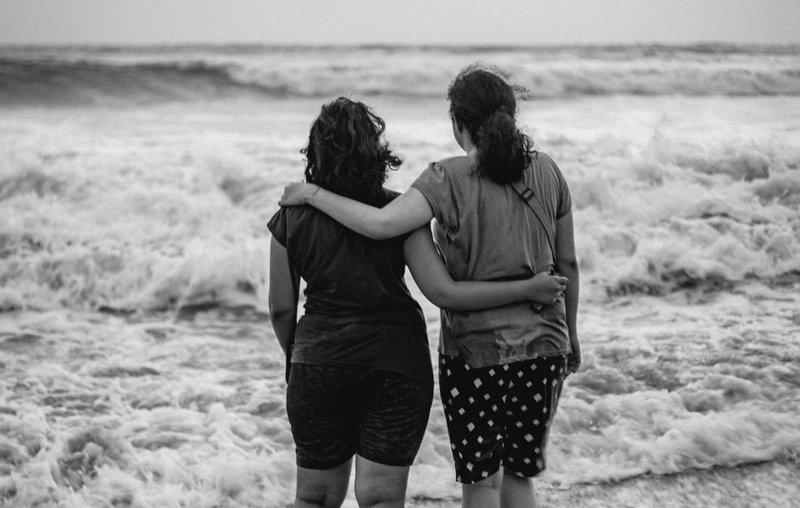 Image of two women in front of the ocean