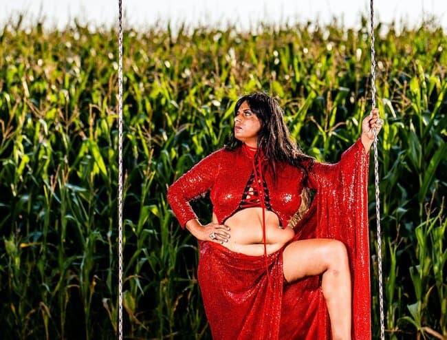 Image of a woman in a red dress standing in nature