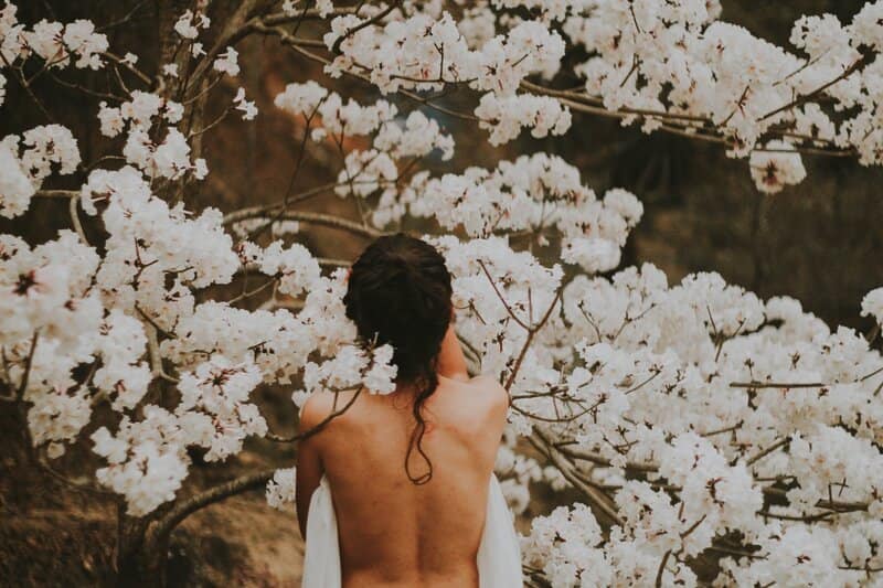 Image of a woman standing in front of white flowers