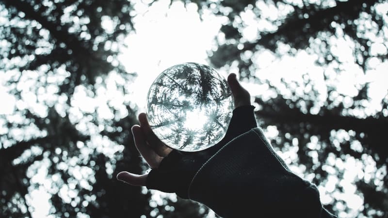 Image of a person holding up a glass ball to the sky